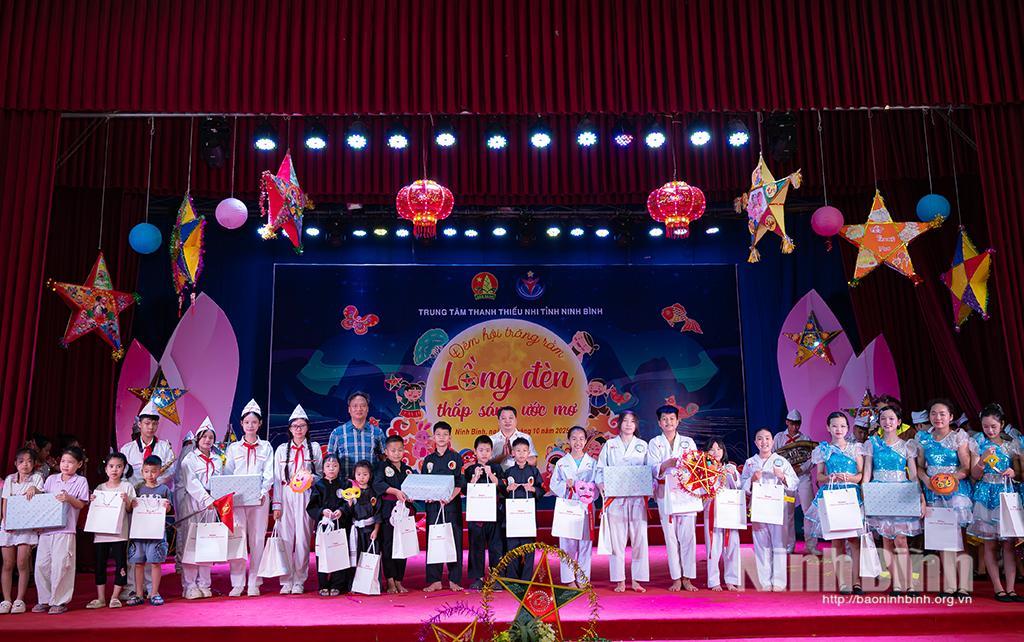 Ban Tổ chức trao giải và tặng quà cho các em thiếu nhi tham dự trò chơi vẽ mặt nạ.