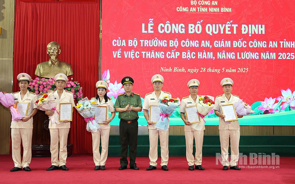 Đồng chí Đại tá Đinh Việt Dũng, Giám đốc Công an tỉnh trao Quyết định và tặng hoa chúc mừng đại diện cán bộ, chiến sĩ được nâng hệ số lương cấp bậc hàm Thượng tá.