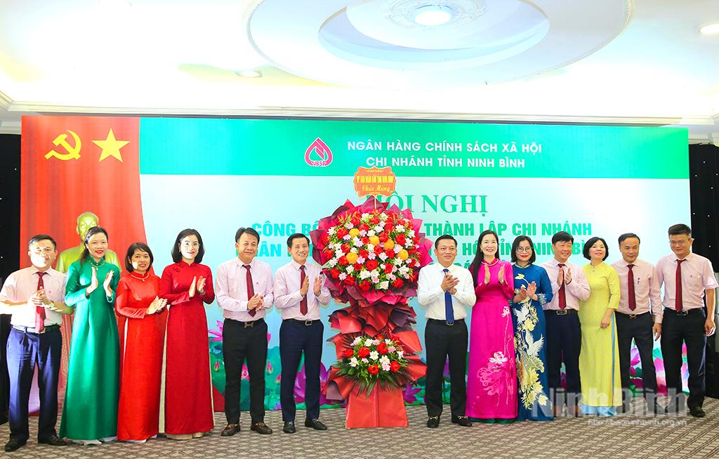Đồng chí Nguyễn Cao Sơn, Tỉnh ủy viên, Phó Chủ tịch UBND tỉnh tặng hoa chúc mừng Ngân hàng CSXH Chi nhánh tỉnh Ninh Bình.